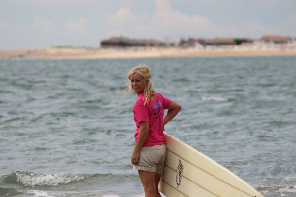 Juliet walking with surfboard to sea