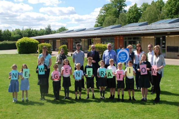 Children and adults holding up sign for New generation in park