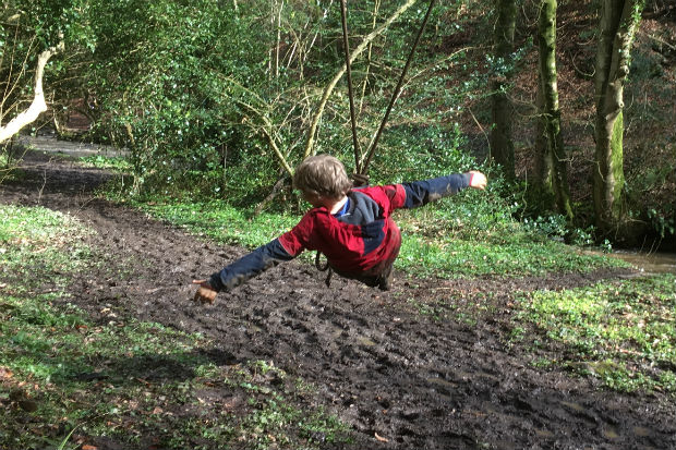 A child sitting on a swing made of rope